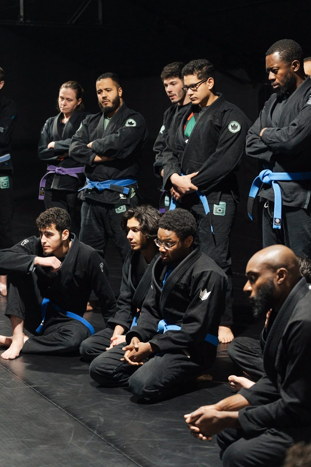 Groupe d'élèves Invictus rassemblés sur le tatami, à l'écoute du coach